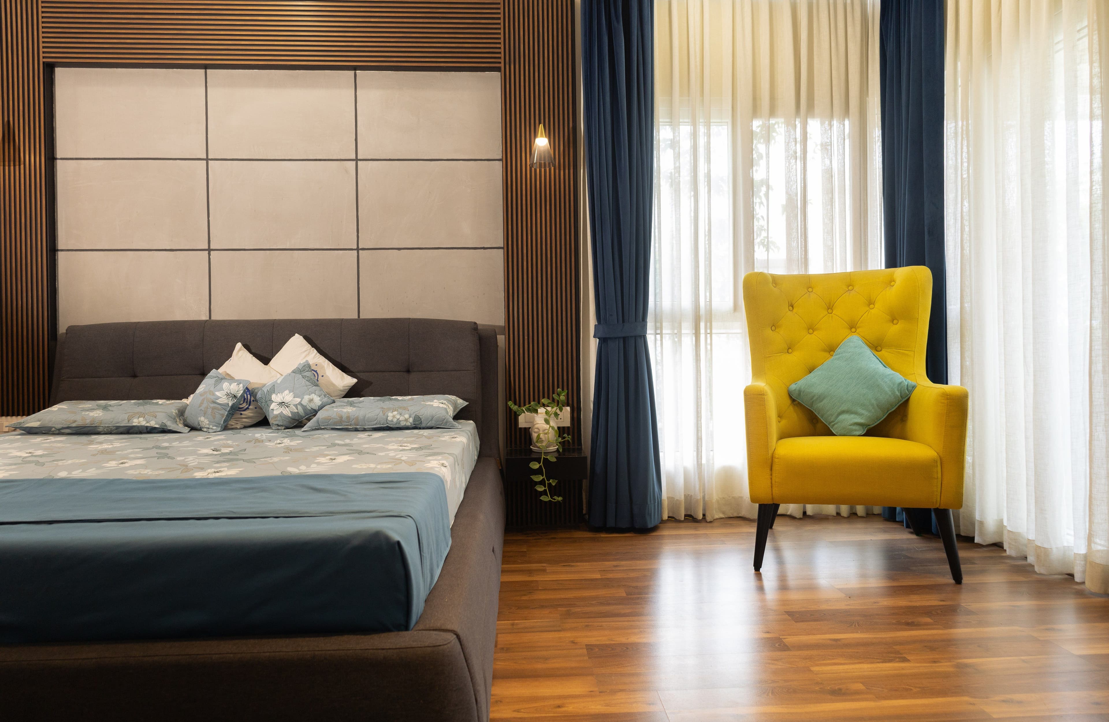 Master bedroom with upholstered headboard and wingback chair