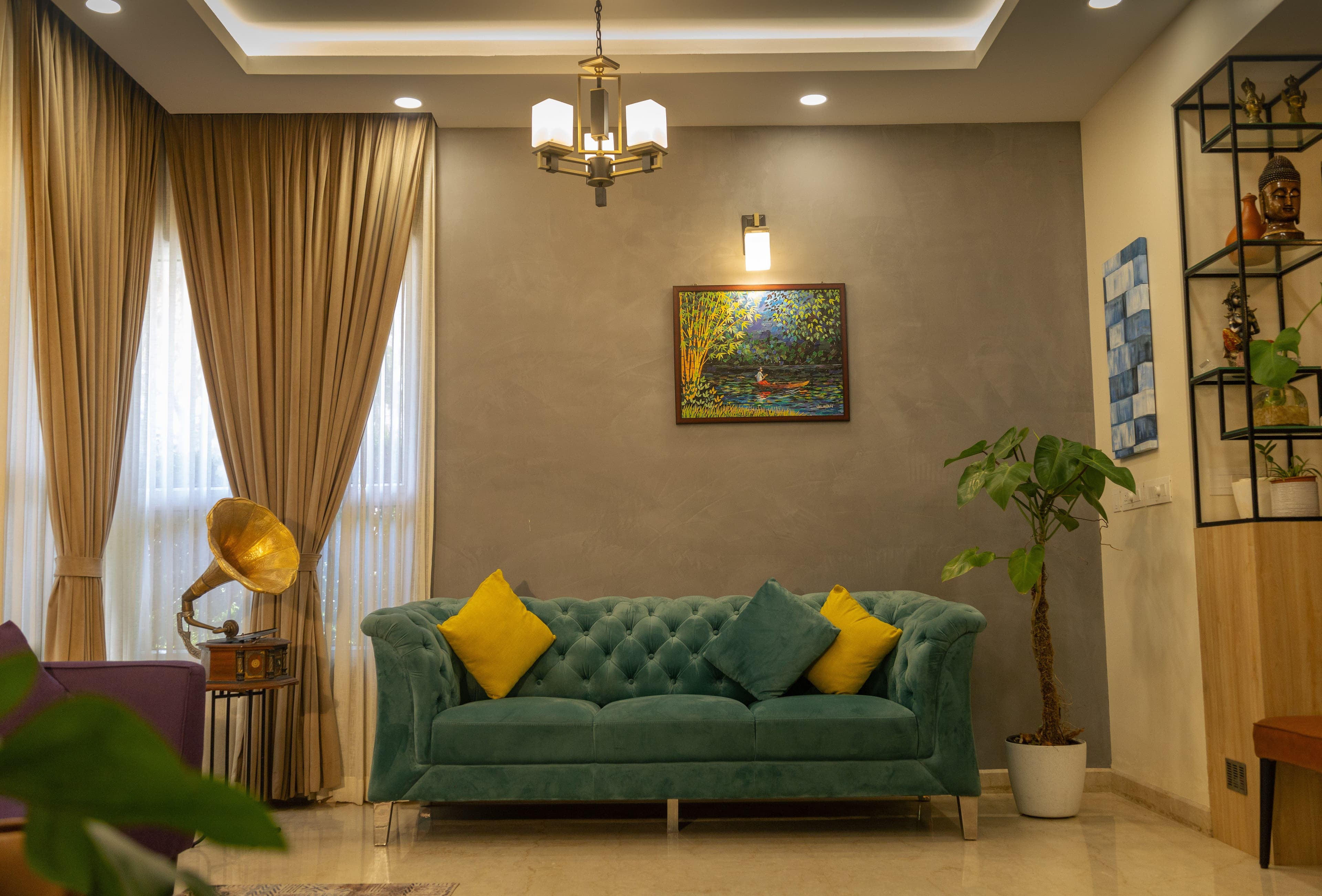 Living room with teal chesterfield sofa and yellow cushions